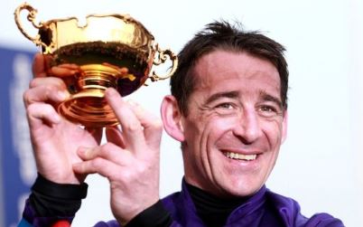 Victorious jockey holds aloft Cheltenham Gold Cup